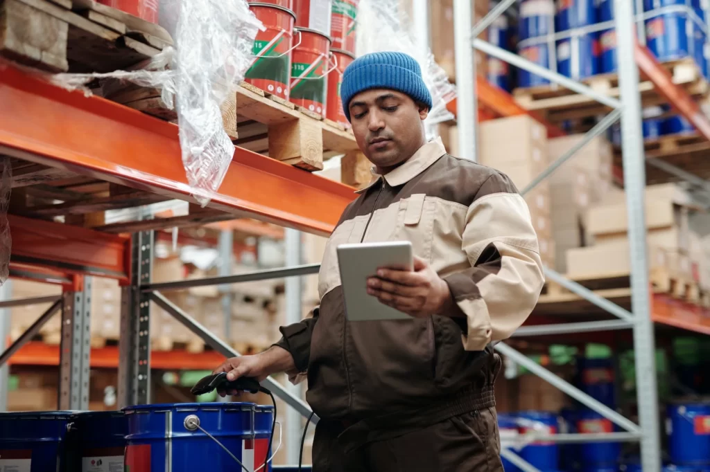 man holding tablet scanning in product at warehouse